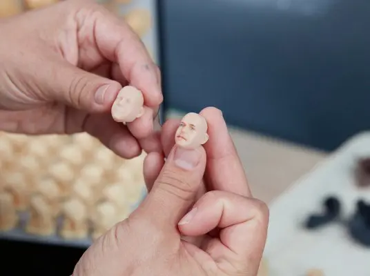 Manos sosteniendo cabeza de muñeco personalizada